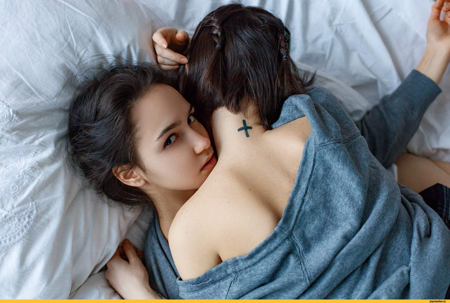Молодая девка с темными волосами ласкается с приятелем и его подружкой на кровати