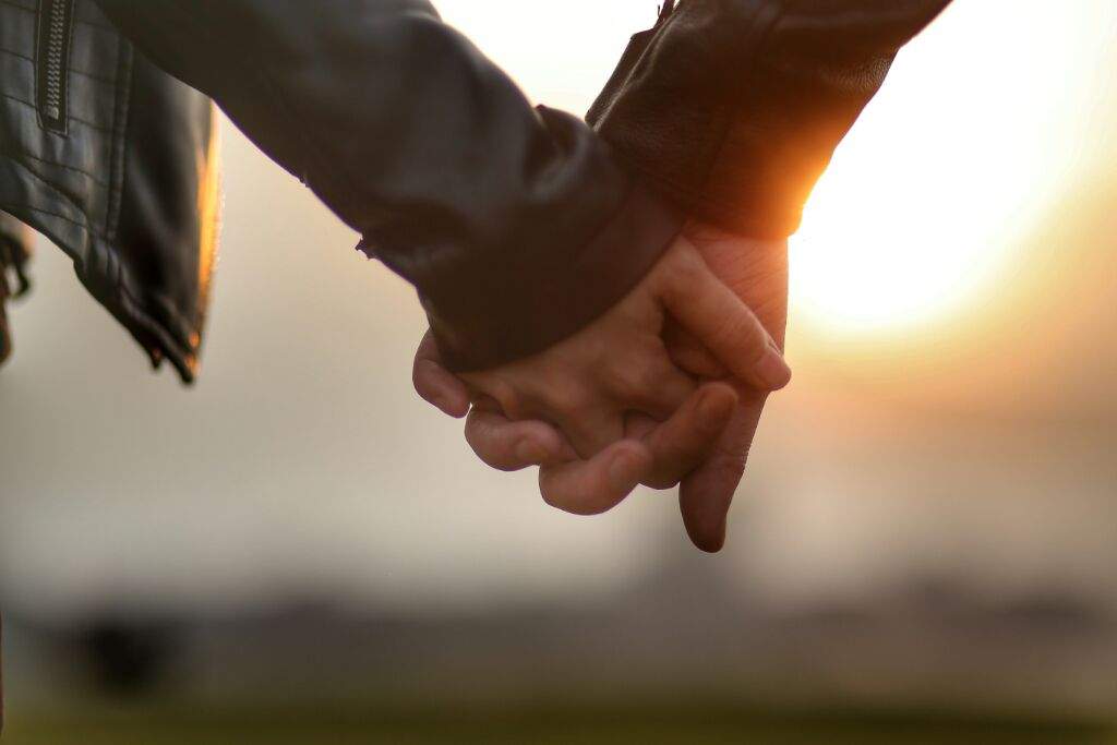 motorcycle couple holding hands