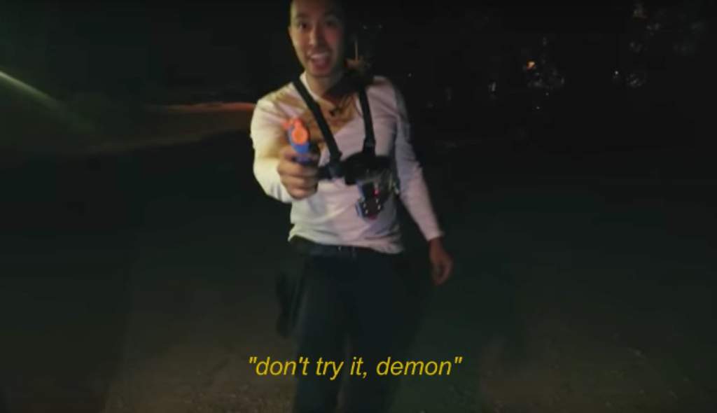 screenshot of Ryan Bergara from Buzzfeed Unsolved pointing a nerf water gun towards the views. the image is subtitled "Don't try it demon!"