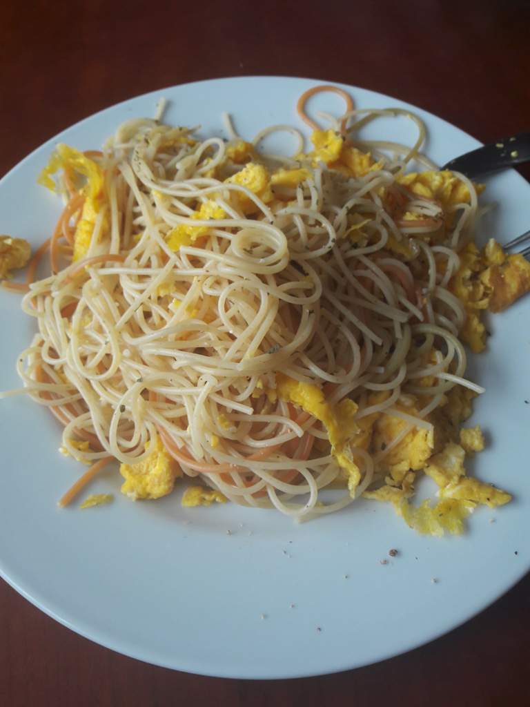 Spaghetti with scrambled eggs, seasoned with black pepper and parsley